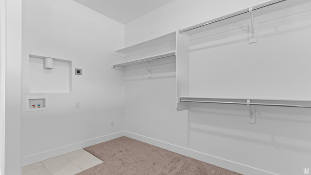 4170 North 560th West, Unit 6 Tooele, UT 84074 - Photo 13 of 20 Dedicated laundry area featuring a tile floor section, wall connections for washer and dryer, and integrated shelving with hanging rods