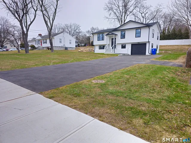 a front view of a house with a yard and trees