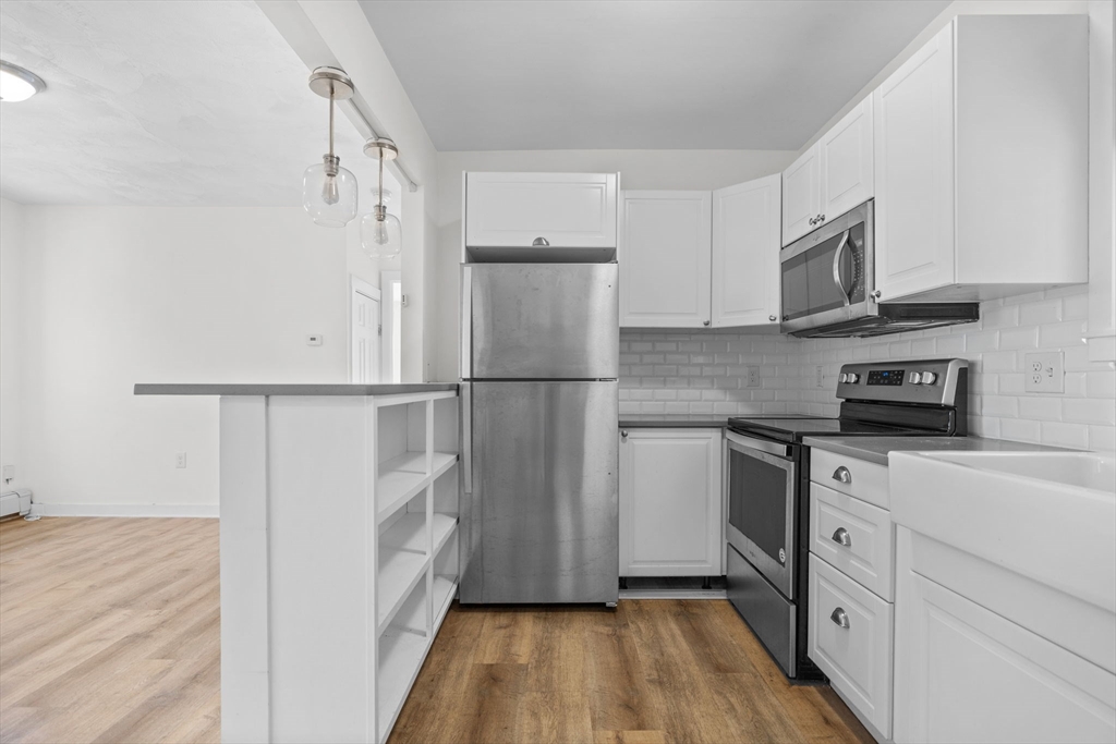 300 Marginal Street, Unit 3 Boston, MA 02128 - Photo 11 of 19 a kitchen with stainless steel appliances granite countertop a refrigerator sink and white cabinets