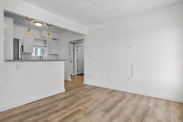 a view of a kitchen with wooden floor and a sink
