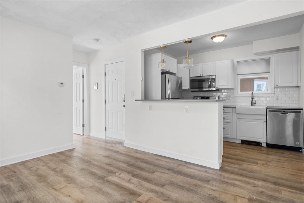 300 Marginal Street, Unit 3 Boston, MA 02128 - Photo 8 of 19 a kitchen with kitchen island a white counter top space stainless steel appliances and cabinets