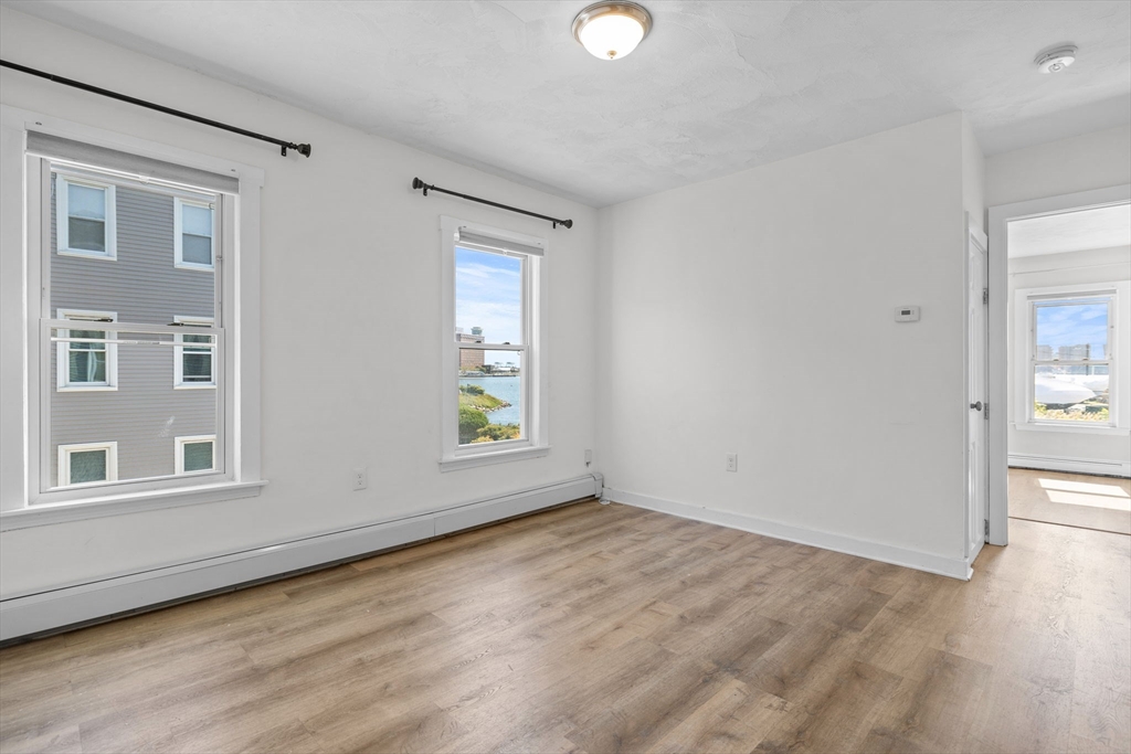 300 Marginal Street, Unit 3 Boston, MA 02128 - Photo 10 of 19 an empty room with wooden floor and windows