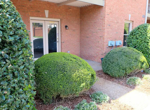 front view of a brick house with a yard