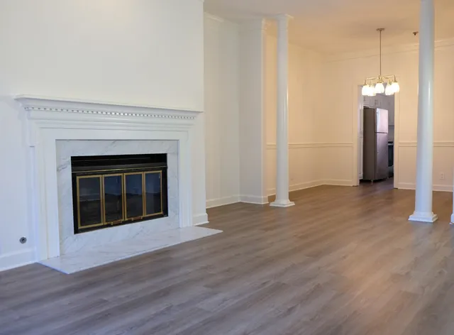 a view of a livingroom with a fireplace and wooden floor