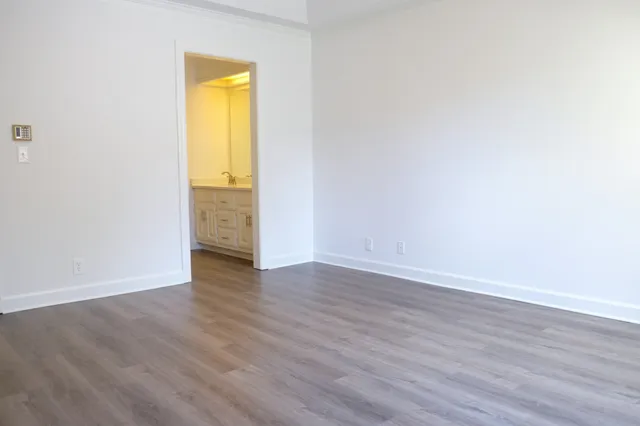 an empty room with wooden floor and a window