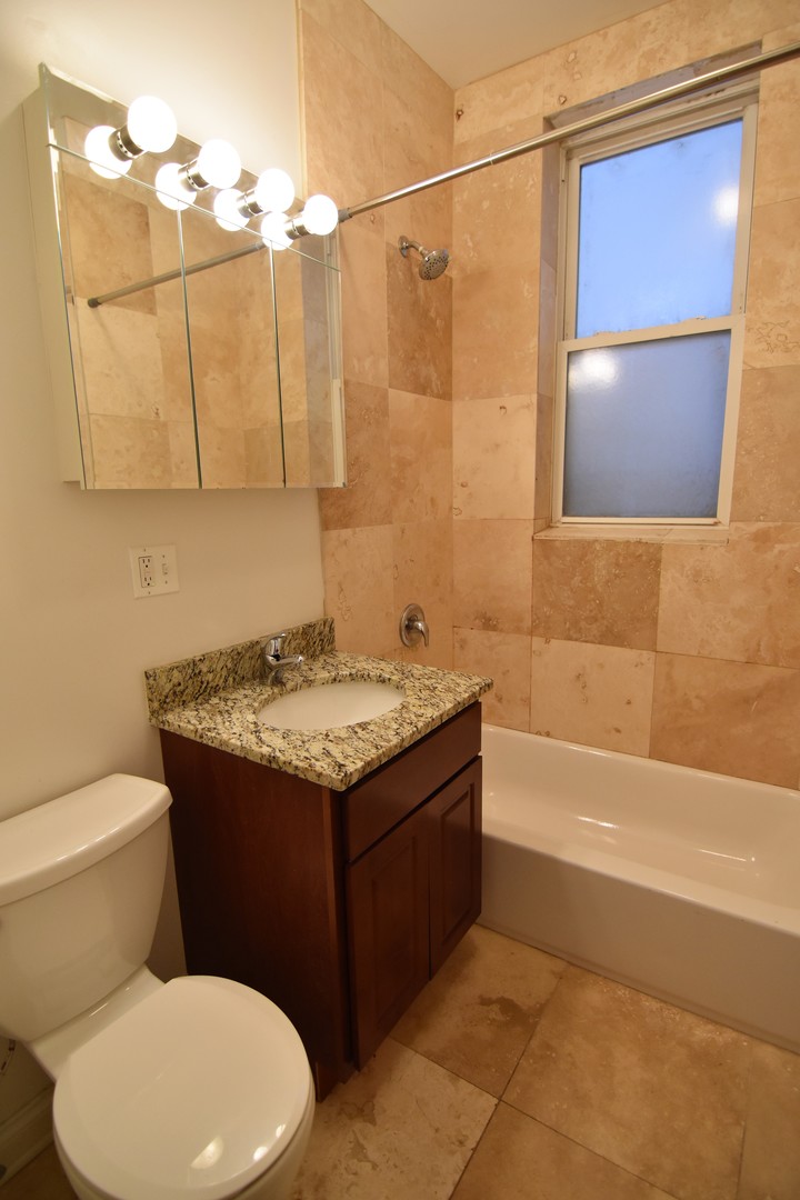 953 West Fletcher Street, Unit 1 Chicago, IL 60657 - Photo 14 of 23 a bathroom with a granite countertop sink toilet and shower