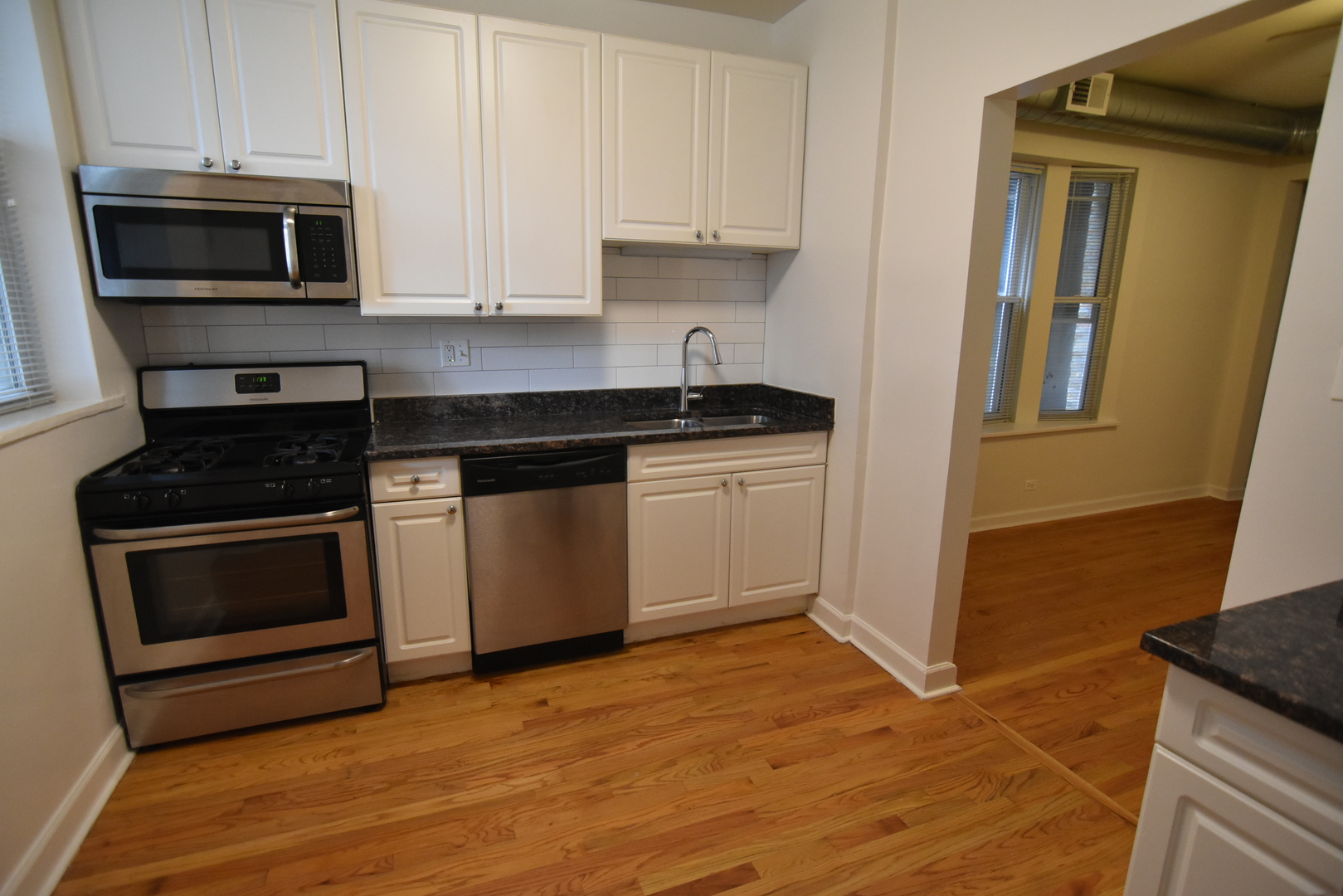 953 West Fletcher Street, Unit 1 Chicago, IL 60657 - Photo 2 of 23 a kitchen with granite countertop a stove top oven microwave and cabinets