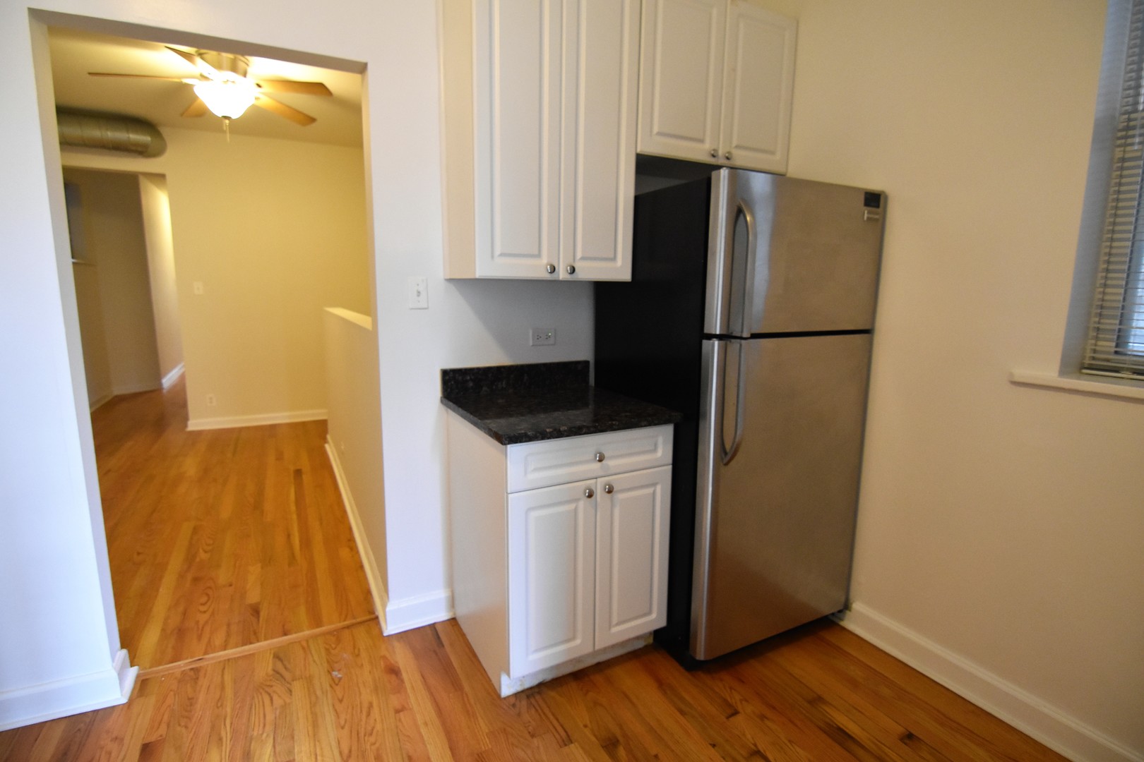 953 West Fletcher Street, Unit 1 Chicago, IL 60657 - Photo 5 of 23 a kitchen with a refrigerator and wooden floor