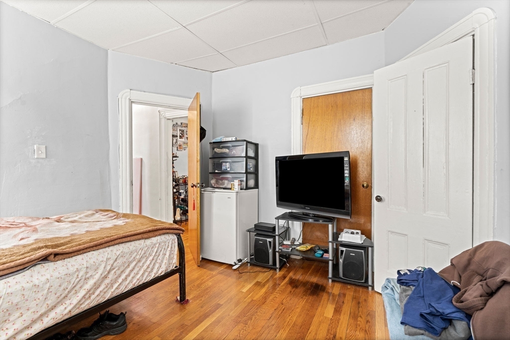 67 School Street Everett, MA 02149 - Photo 27 of 37 a bedroom with a bed and a flat screen tv