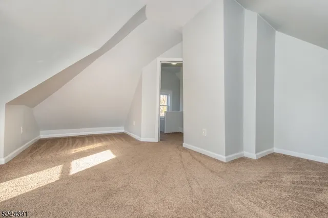 a view of an empty room with closet and a window
