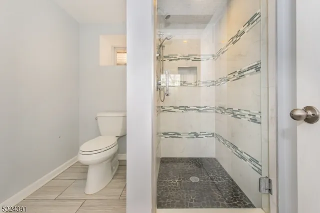 a bathroom with a toilet and a shower