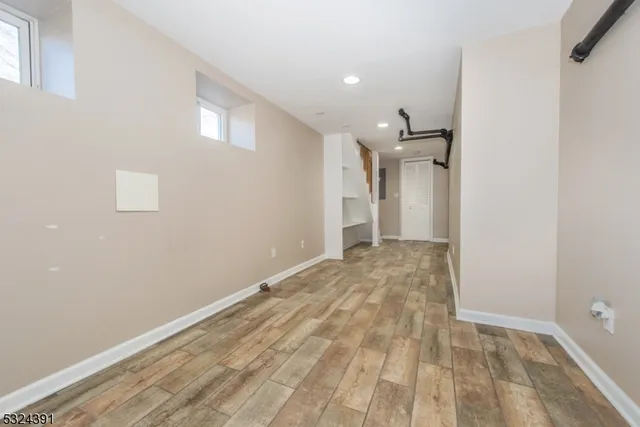 a view of a big room with wooden floor and windows