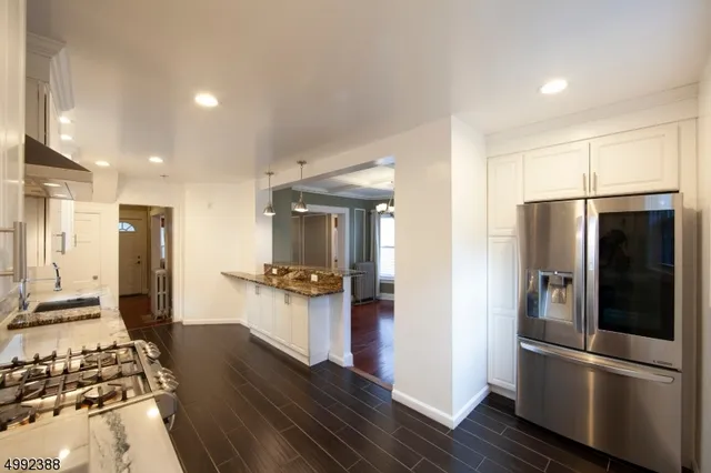 a kitchen with stainless steel appliances a refrigerator and wooden floor