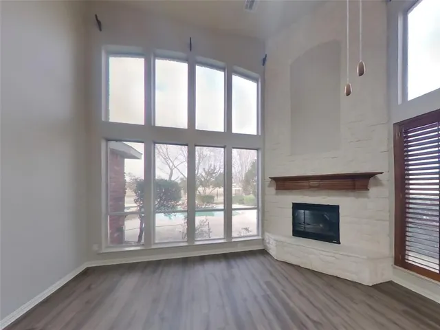 wooden floor fireplace and windows in an empty room