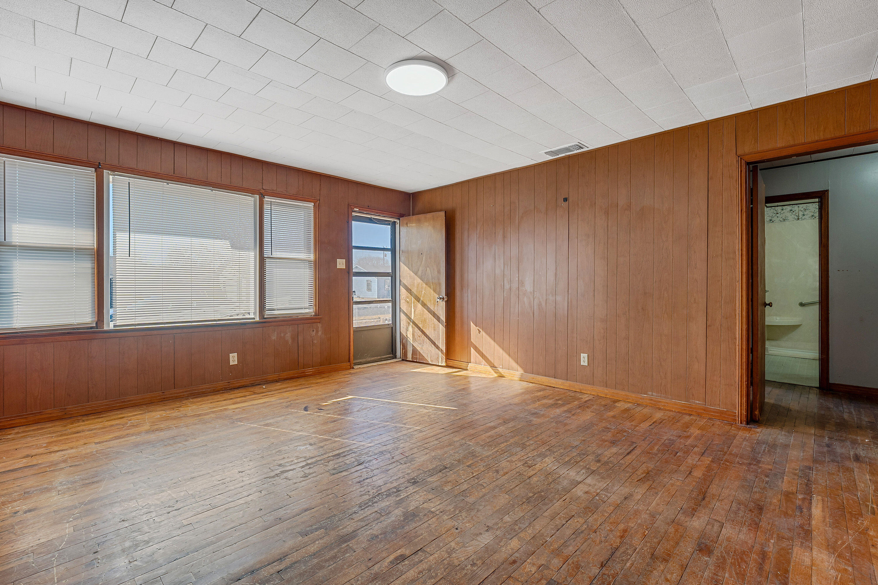 2808 1st Street Lubbock, TX 79415 - Photo 3 of 9 an empty room with wooden floor and windows