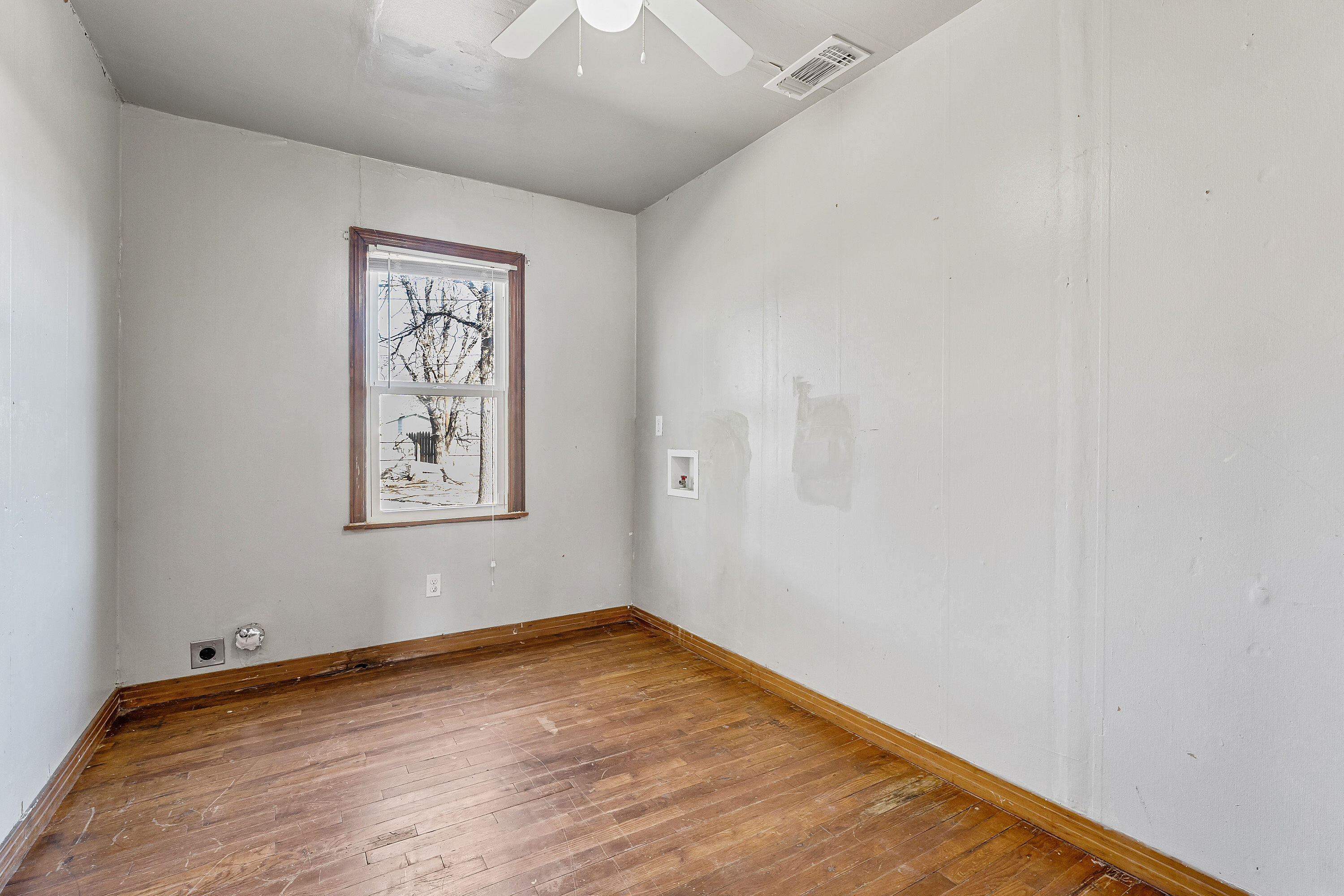 2808 1st Street Lubbock, TX 79415 - Photo 7 of 9 an empty room with a window and wooden floor