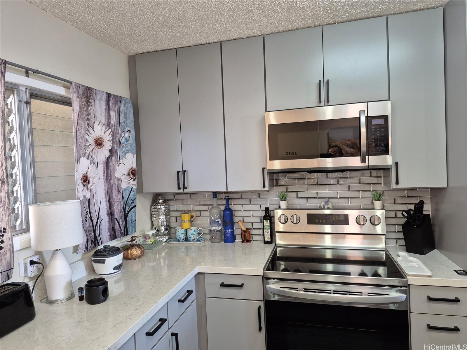 469 Ena Road, Unit 2810 Honolulu, HI 96815 - Photo 3 of 15 a kitchen with a stove and a microwave