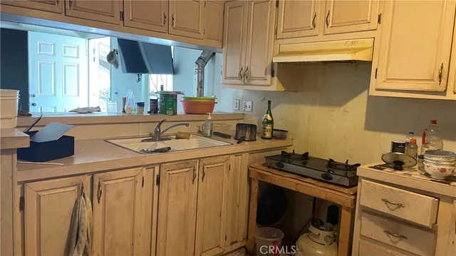 a kitchen with stainless steel appliances a sink stove and cabinets