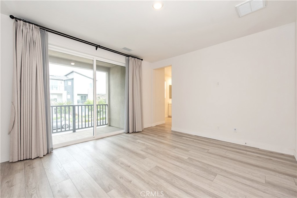 163 Restore Irvine, CA 92618 - Photo 12 of 45 a view of an empty room with wooden floor and a window