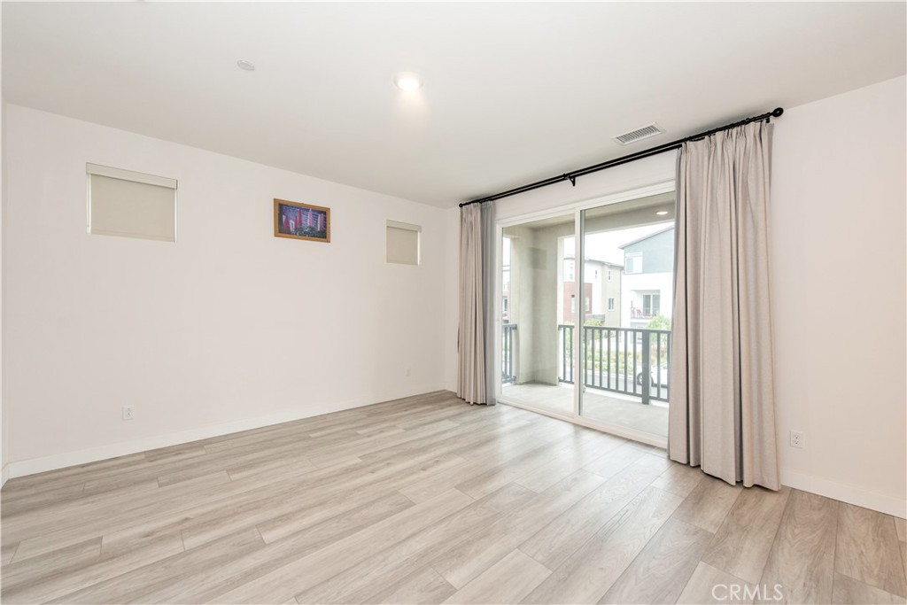 163 Restore Irvine, CA 92618 - Photo 13 of 45 an empty room with wooden floor and windows