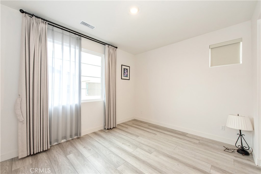 163 Restore Irvine, CA 92618 - Photo 16 of 45 an empty room with wooden floor and windows