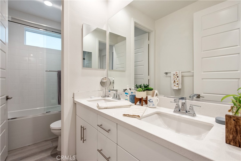 163 Restore Irvine, CA 92618 - Photo 18 of 45 a bathroom with a granite countertop double vanity sink a mirror and a toilet