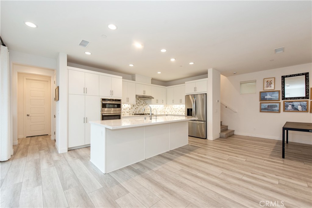 163 Restore Irvine, CA 92618 - Photo 6 of 45 a kitchen with stainless steel appliances granite countertop a refrigerator sink and white cabinets
