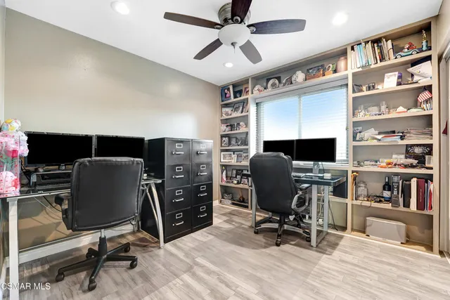 a view of a workspace with furniture and a bookshelf