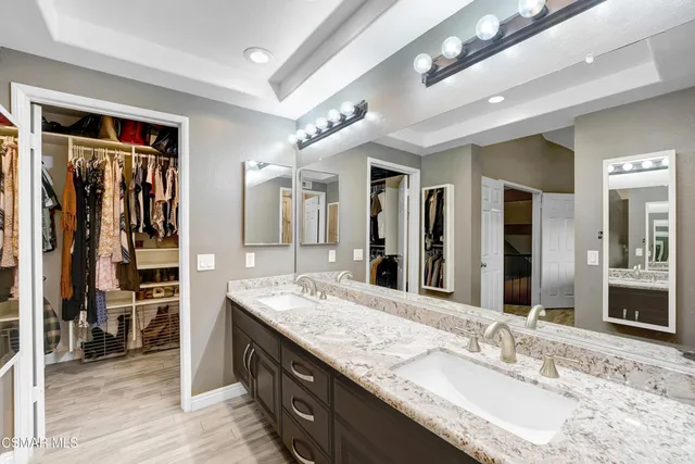 a bathroom with a granite countertop double vanity sink and a mirror