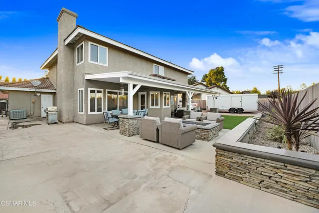 a front view of a house with swimming pool and furniture