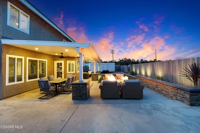 a living room with patio furniture and a fireplace