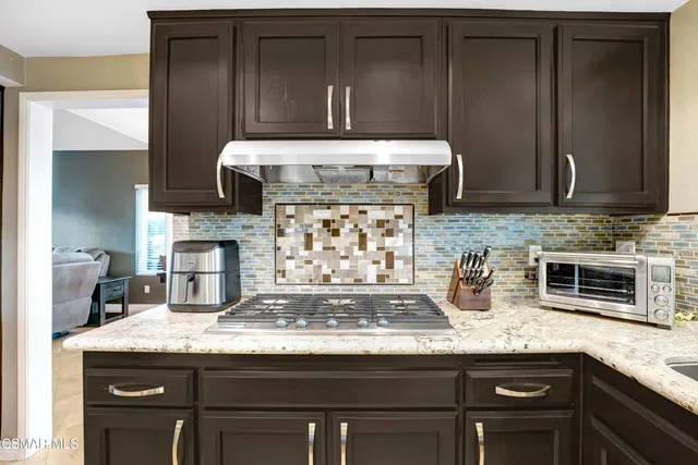 a kitchen with granite countertop a stove a oven a sink dishwasher and cabinets