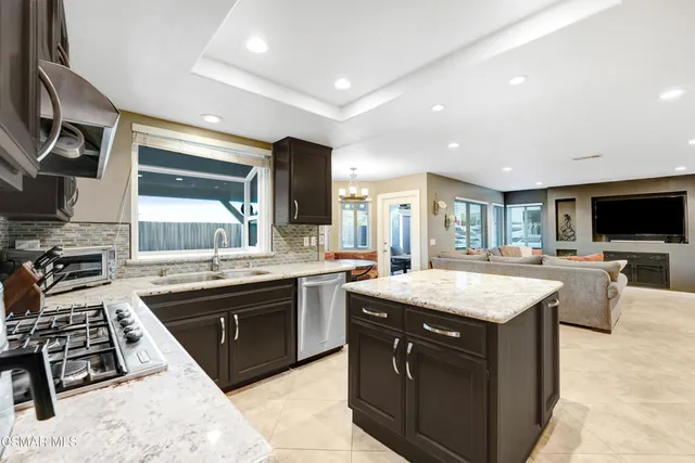 a large kitchen with stainless steel appliances granite countertop a sink and a stove