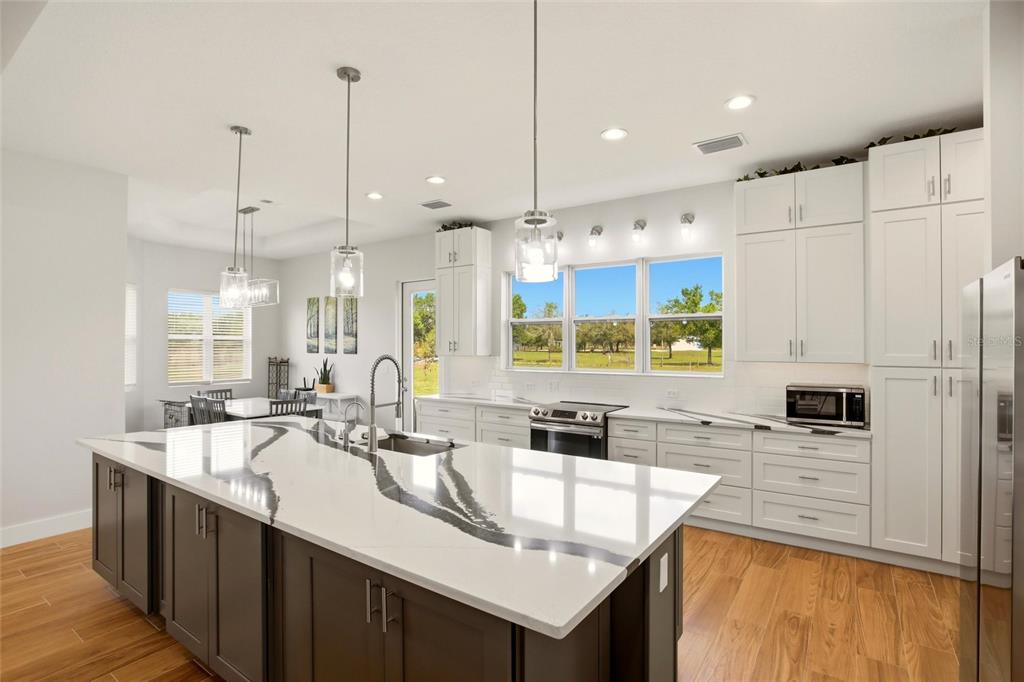 10080 Wauchula Road Myakka City, FL 34251 - Photo 11 of 55 a kitchen with stainless steel appliances a stove sink and cabinets