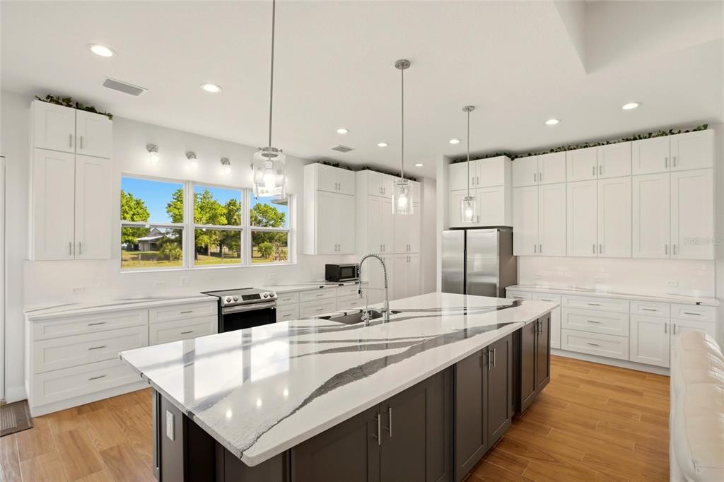 10080 Wauchula Road Myakka City, FL 34251 - Photo 12 of 55 a kitchen with stainless steel appliances kitchen island granite countertop a sink a stove and a refrigerator