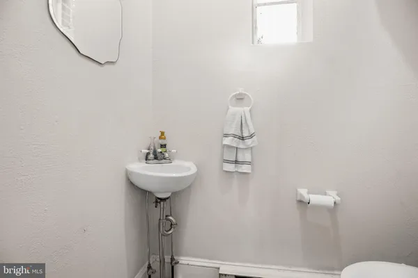 a bathroom with a sink a toilet and a mirror