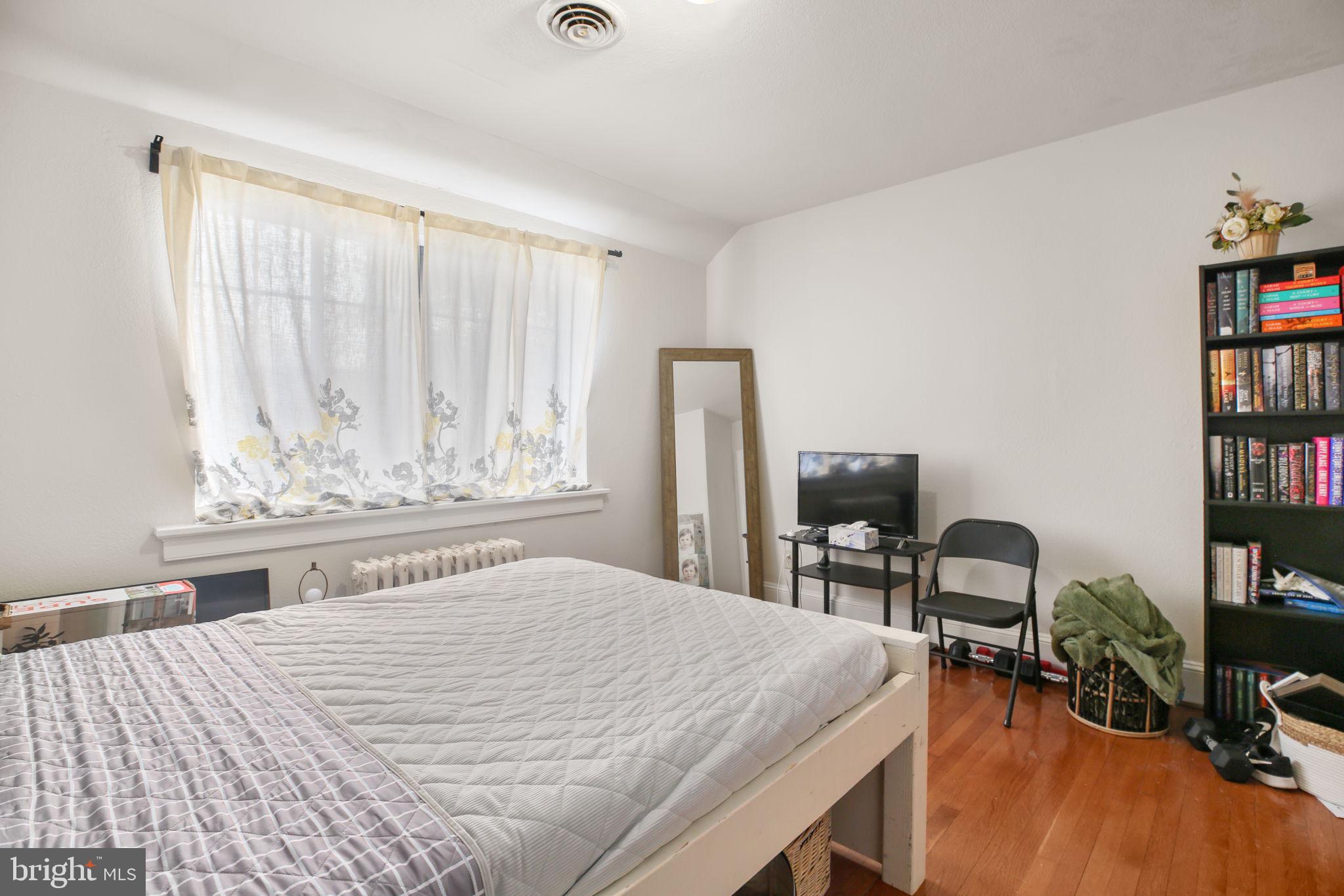 1717 Highland Road Fredericksburg, VA 22401 - Photo 21 of 40 a bedroom with a bed and a bookshelf with wooden floor