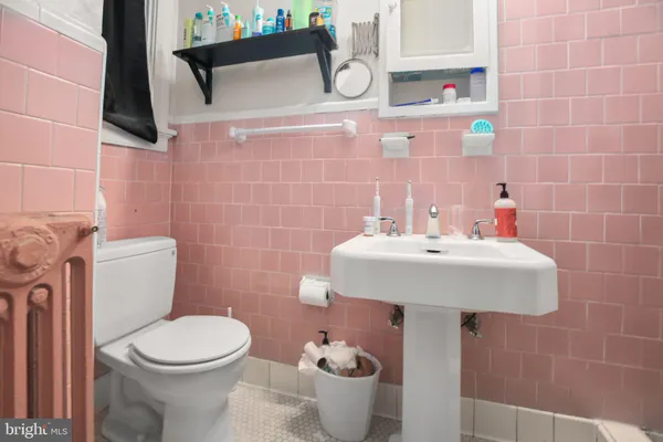 a bathroom with a sink a toilet and mirror