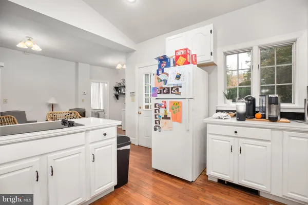 a white kitchen with sink and refrigerator