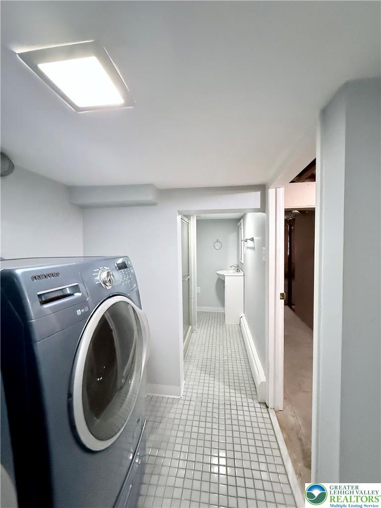 5540 Main Street Whitehall, PA 18052 - Photo 41 of 53 A well-lit laundry area connects to a compact, functional bathroom.