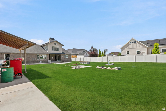 580 North 300 East Logan, UT 84321 - Photo 69 of 74 Expansive grassy backyard featuring a paved patio, a white privacy fence, and a covered patio area