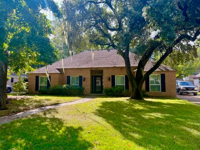a front view of a house with a yard and trees