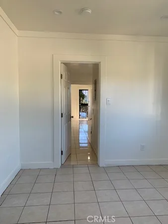 a view of an empty room with closet and a window