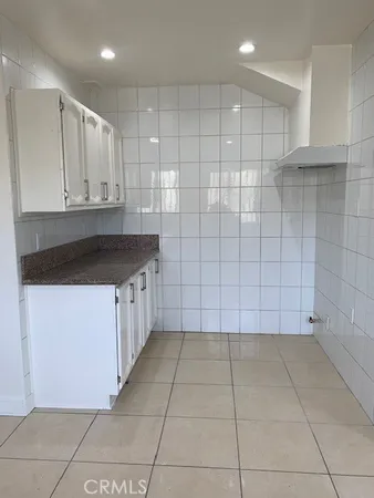 a kitchen with granite countertop white cabinets and a sink