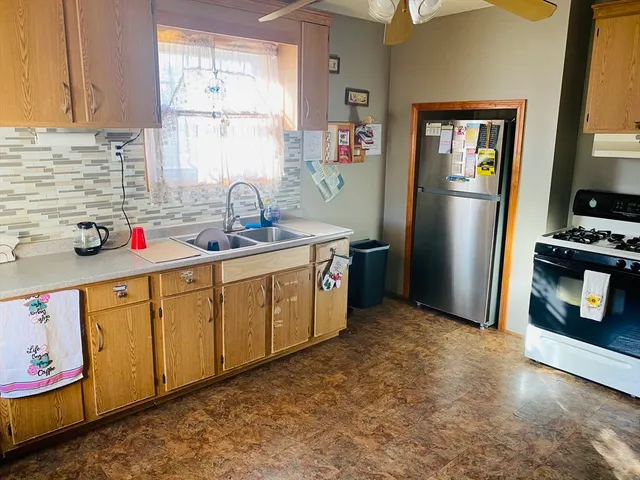 a kitchen with stainless steel appliances granite countertop a refrigerator and a stove top oven