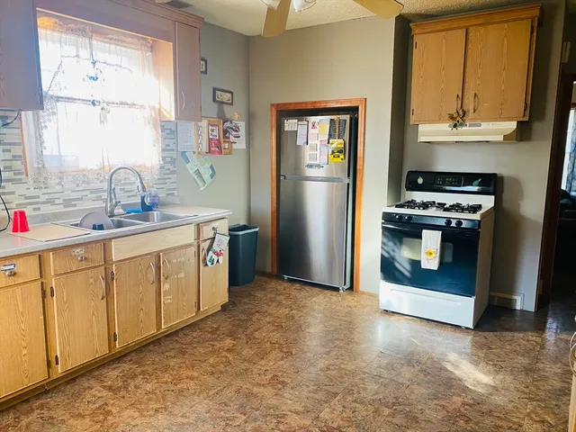 a kitchen with stainless steel appliances granite countertop a stove a sink and a refrigerator