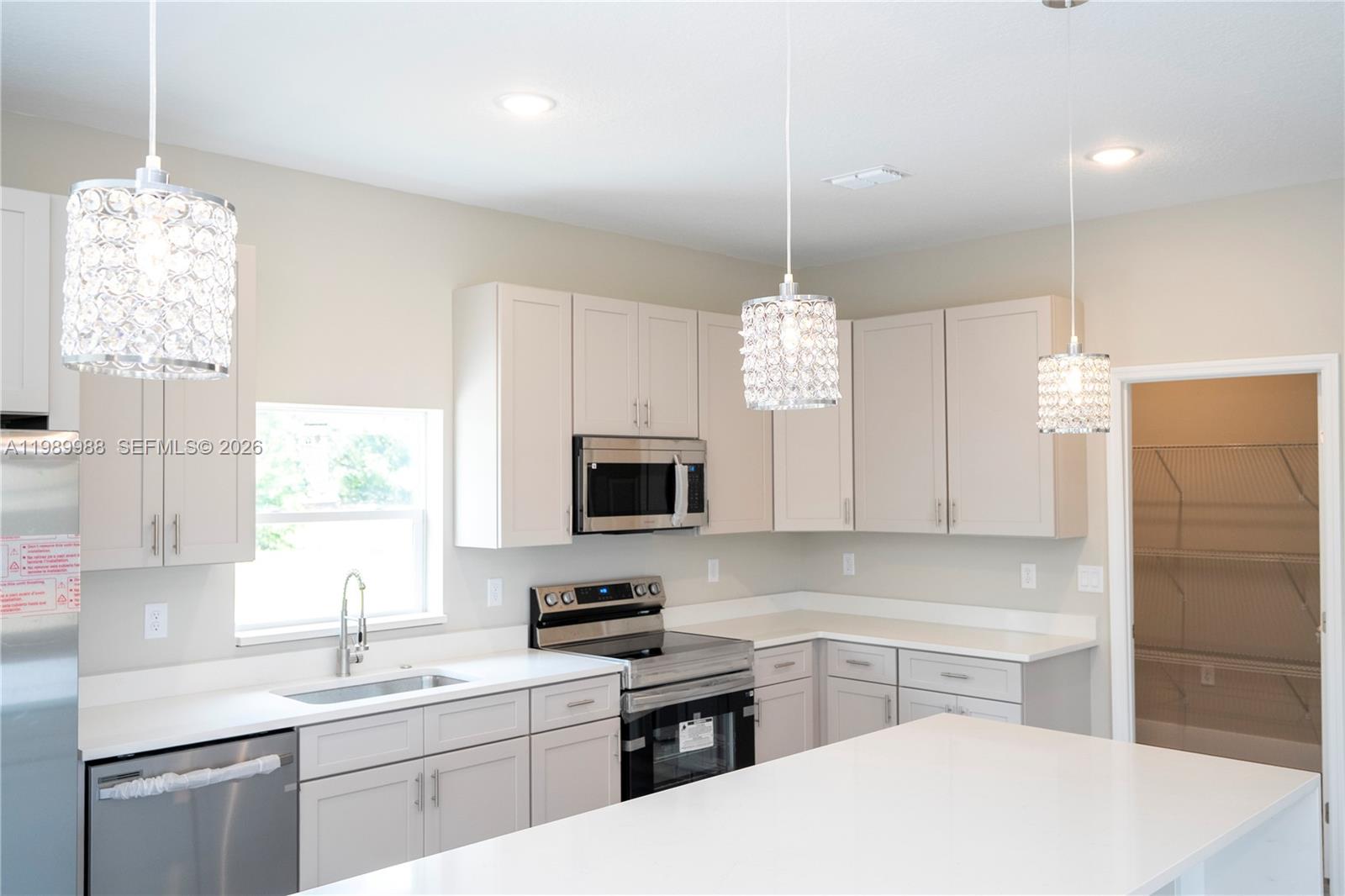 7916 Granada Road Sebring, FL 33876 - Photo 12 of 60 a kitchen with a sink a window and stainless steel appliances