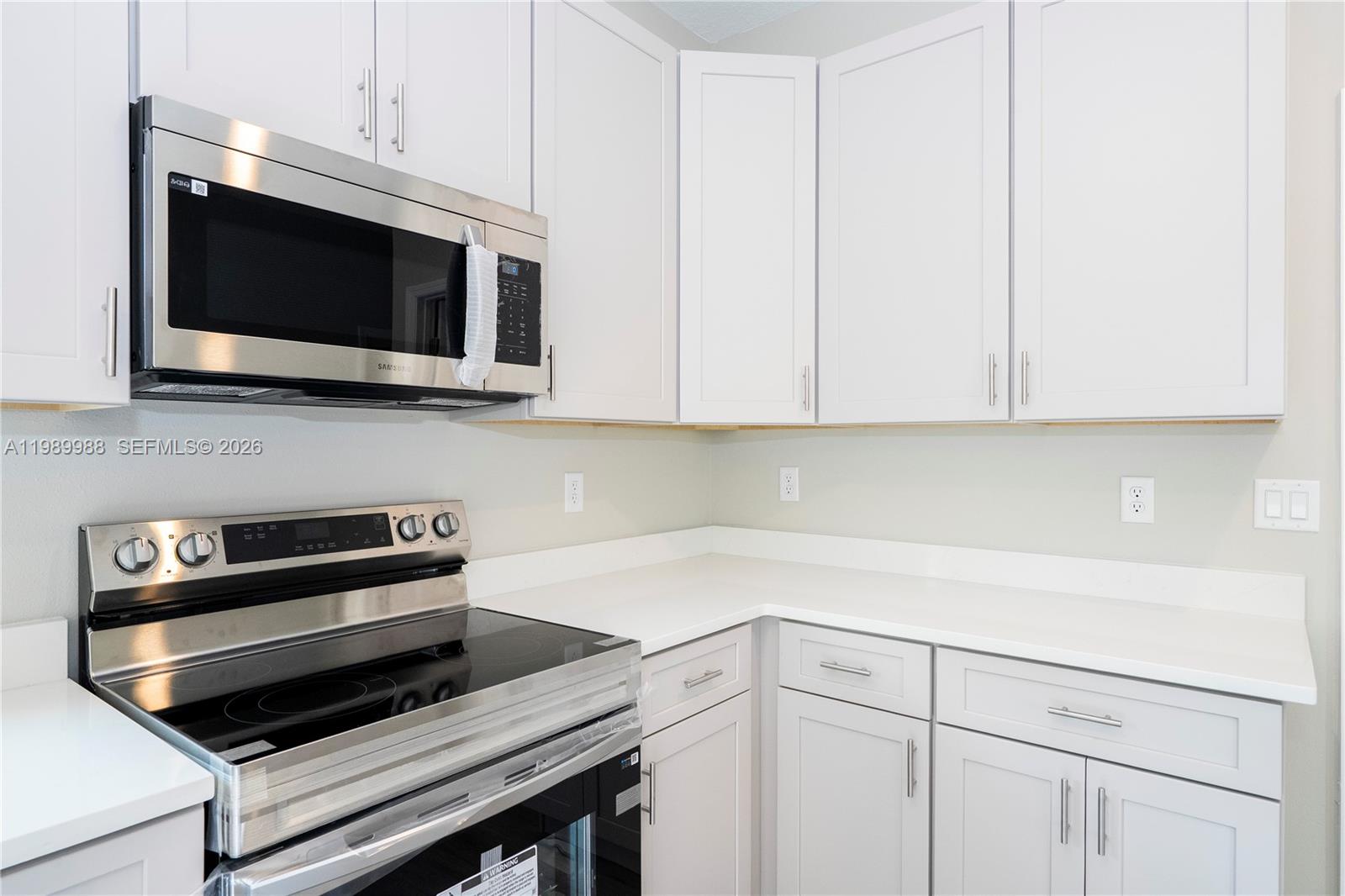 7916 Granada Road Sebring, FL 33876 - Photo 13 of 60 a kitchen with a stove microwave and cabinets