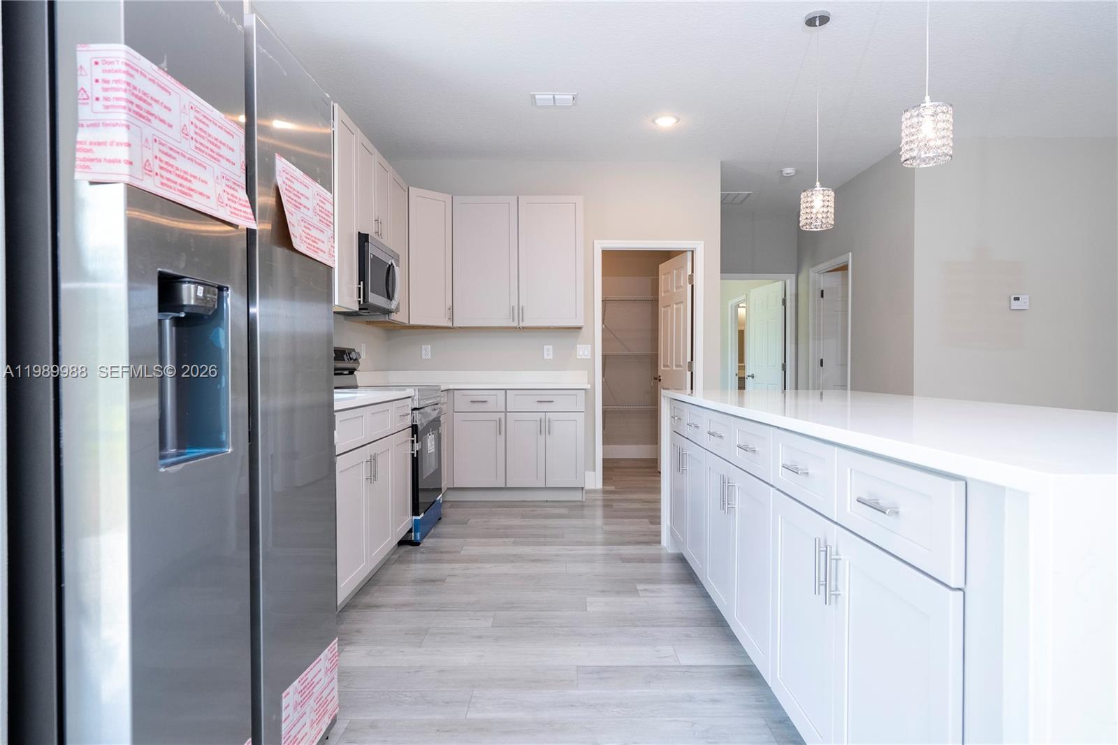 7916 Granada Road Sebring, FL 33876 - Photo 16 of 60 a kitchen with white cabinets and stainless steel appliances