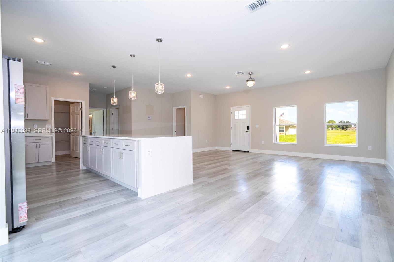 7916 Granada Road Sebring, FL 33876 - Photo 17 of 60 a view of a big room with wooden floor and a kitchen